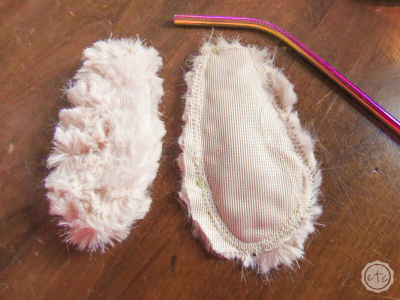 Showing the bunny arms next to each other (one with the correct fuzzy fabric on the outside and one still inside out next to the metal straw).