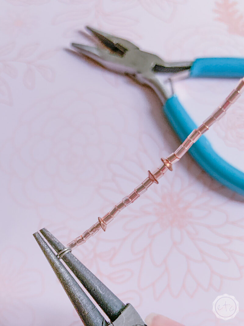 Using a pair of round nose pliers to form a loop