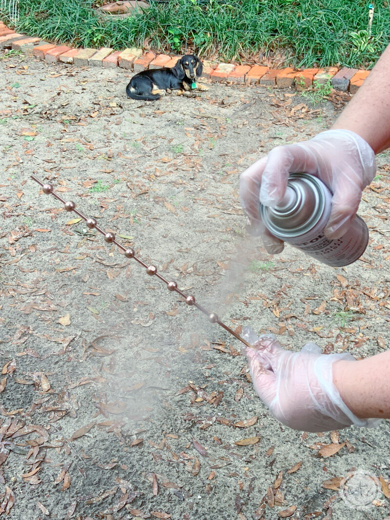 Spray painting a few wooden beads on a bamboo skewer. 